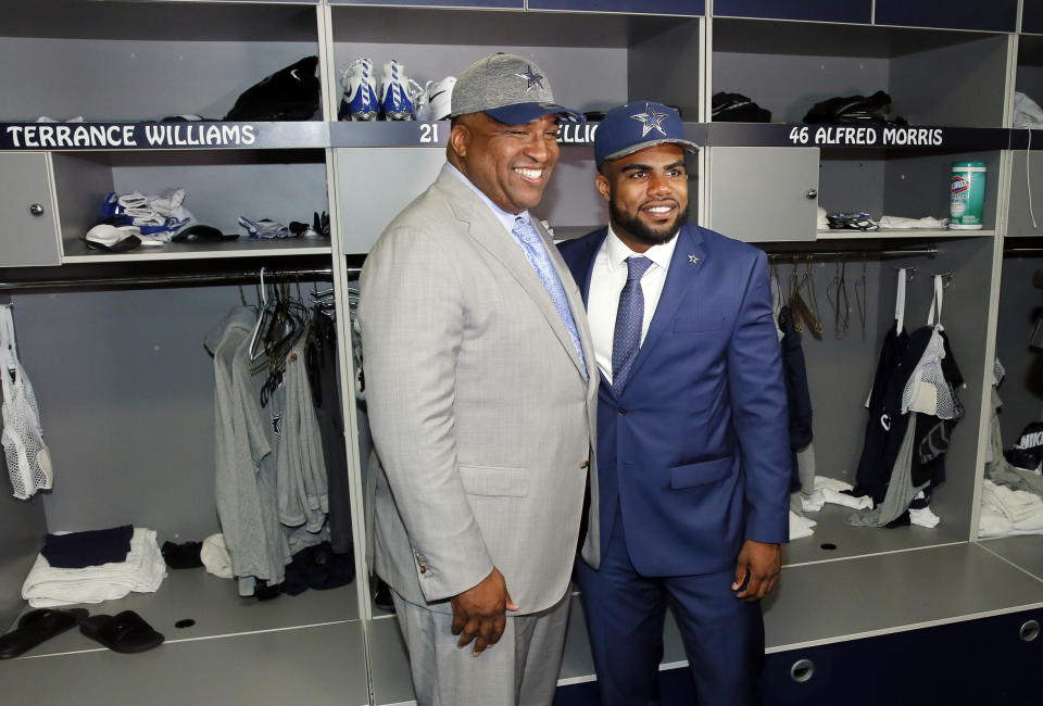 Stacy Elliott, left, poses with his son Ezekiel, right, the Dallas Cowboys NFL football first-round draft pick, in front of  Ezekiel's locker at the team's training facility, Friday, April 29, 2016, in Irving, Texas. (AP Photo/Tony Gutierrez)