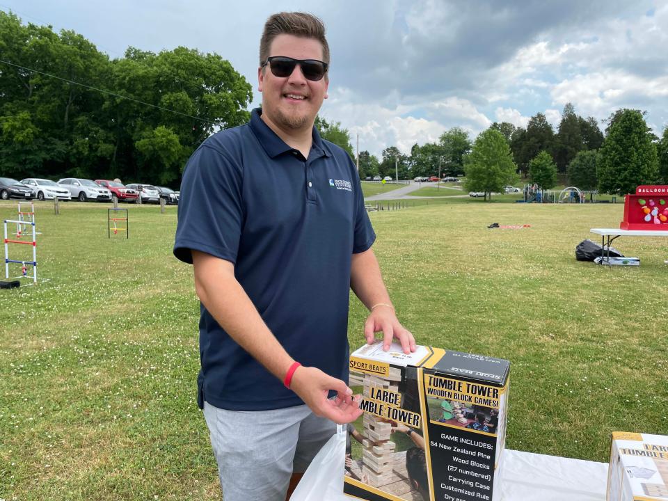 Brandon Gann from Knox County Parks and Rec unpacks a giant game of Jenga at the first Spring Lawn Games Festival held at Carl Cowan Park Sunday, May 22, 2022.