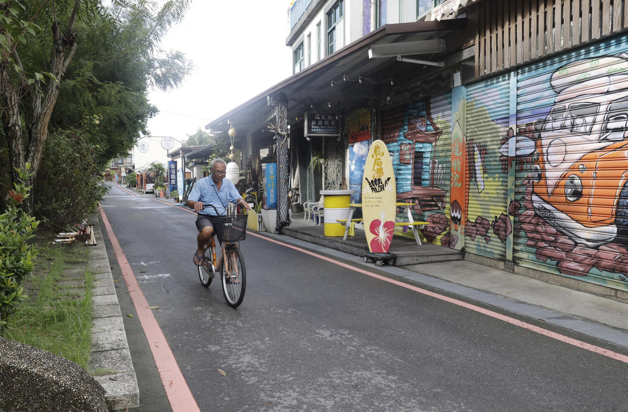 A man rides a bicycle on Surf Street as Typhoon Krathon approaches to Taiwan in Yilan County, eastern coast of Taiwan, Tuesday, Oct. 1, 2024. (AP Photo/Chiang Ying-ying)