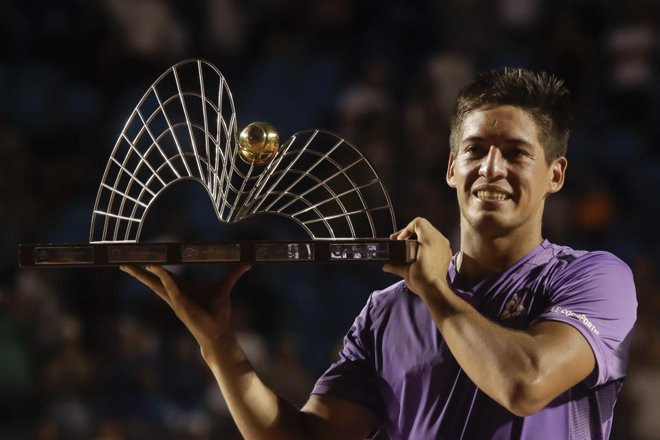 Sebastian Baez holds up his trophy after defeating Mariano Navone, both of Argentina, during the final match of the Rio Open tennis tournament in Rio de Janeiro, Brazil, Sunday, Feb. 25, 2024. (AP Photo/Bruna Prado)