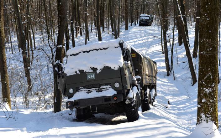 A column of Russian military vehicles is seen abandoned in the snow, in a forest not far from Kharkiv - Sergey Bobok/AFP