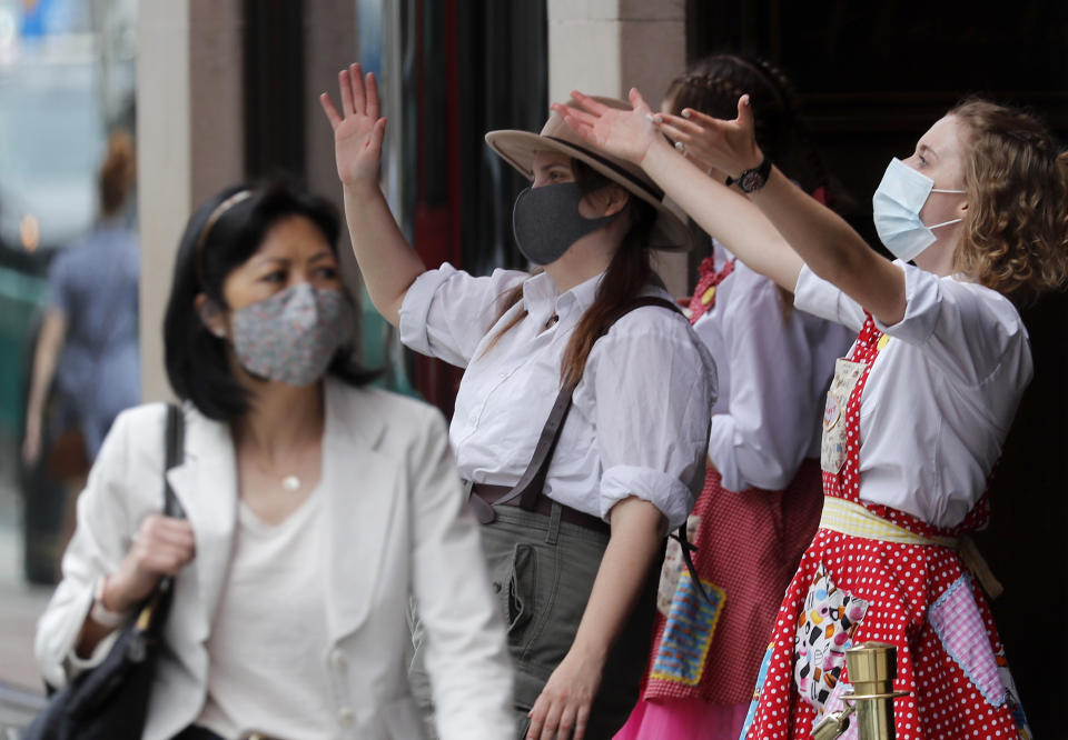 A shopper wearing a face covering walks a toy shop entertainment in London, Tuesday, July 14, 2020.Britain's government is demanding people wear face coverings in shops as it has sought to clarify its message after weeks of prevarication amid the COVID-19 pandemic. (AP Photo/Frank Augstein)