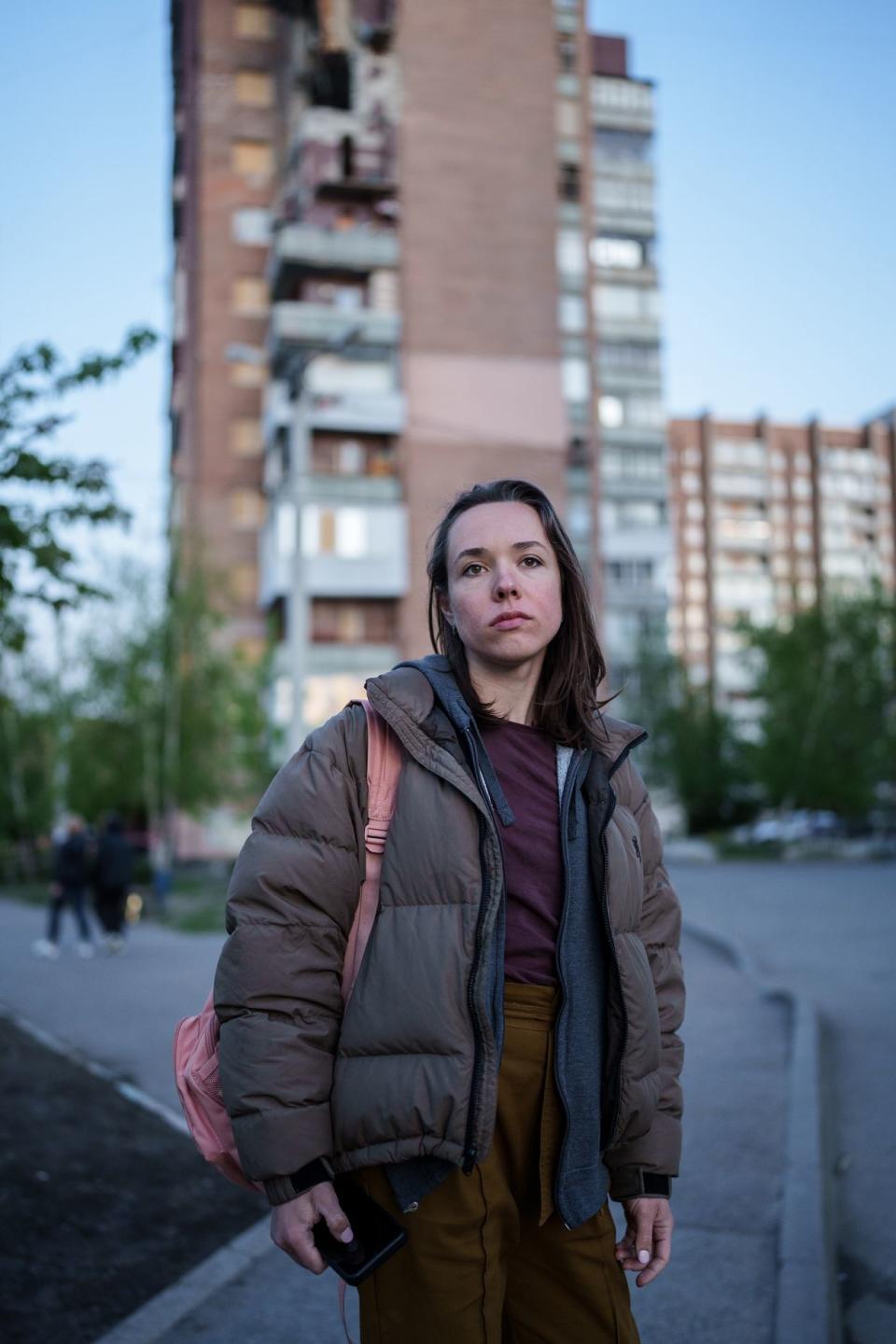 Yulia Kolisnuk, 29, near the building in her neighborhood hit by a Russian Shakhed drone this March in Kharkiv, Ukraine, on April 23, 2024. (Serhii Korovayny/The Kyiv Independent)