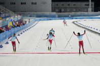 Norway's Joergen Graabak, right, celebrates after finishing ahead of Norway's Jens Luraas Oftebro, left, and Japan's Akito Watabe, center, during the cross-country skiing portion of the individual Gundersen large hill/10km competition at the 2022 Winter Olympics, Tuesday, Feb. 15, 2022, in Zhangjiakou, China. (AP Photo/Aaron Favila)