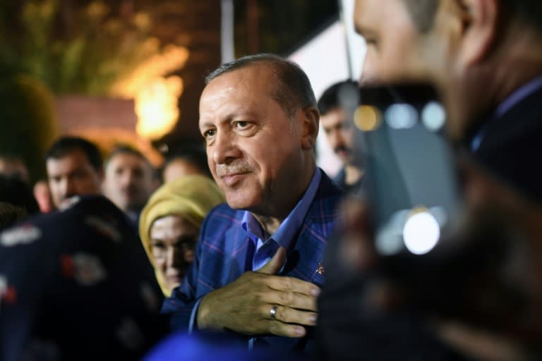 Turkish president Recep Tayyip Erdogan (C), flanked by his wife Emine Erdogan (rear L), acknowledges supporters, during a rally, as he leaves after delivering a speech in Istanbul, on April 16, 2017