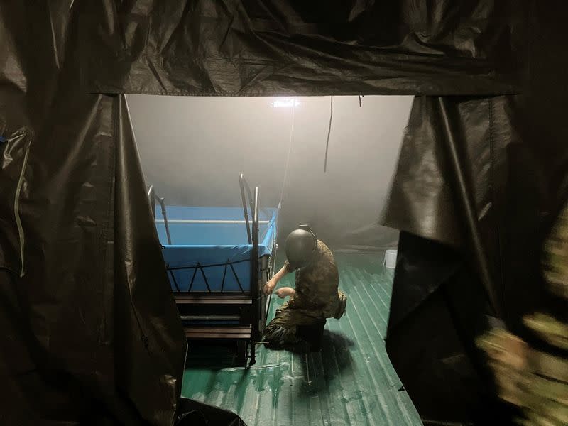 A member of Japan’s Self Defence Forces sets up a makeshift communal bath for survivors of an earthquake in Suzu