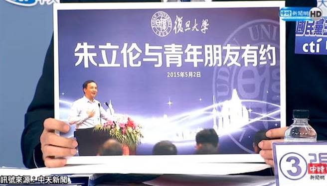 張亞中出示一張照片，顯示朱立倫在復旦大學的演講，背景沒有「中國國民黨」字樣。（取自中天電視網路直播）