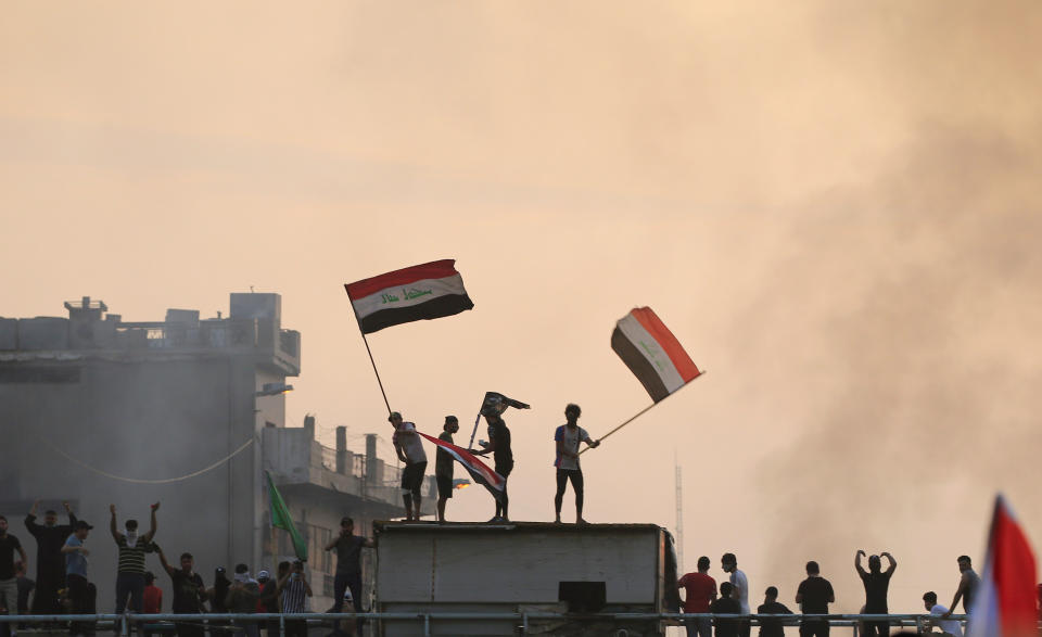 Demonstrators hold Iraqi flags 