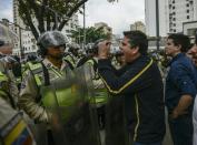 Venezuelan opposition deputy Rafael Guzman (C), confronts National Guard during a protest in front of the National Attorney's General office in Caracas