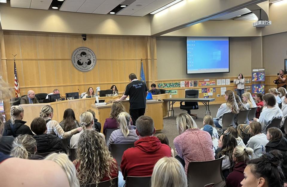 Les Coin (center, at podium), gymnastics coach, speaks to the Sioux Falls School District Board of Education on March 27, 2023 about the need to save the gymnastics program.