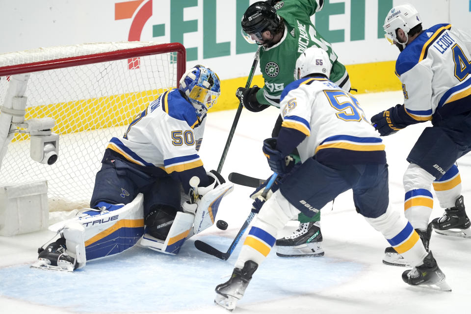 St. Louis Blues goaltender Jordan Binnington (50) blocks a shot from Dallas Stars center Matt Duchene (95) as Colton Parayko (55) and Nick Leddy help defend on the play in the first period of an NHL hockey game in Dallas, Wednesday, April 17, 2024. (AP Photo/Tony Gutierrez)