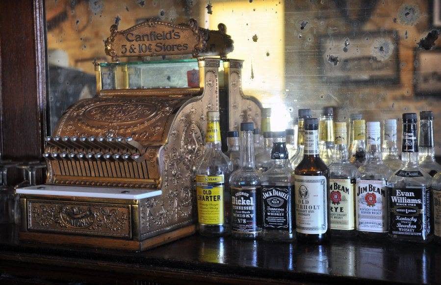 A vintage cash register and bottles of liquor at the Stonewall Saloon Museum in Saint Jo, Texas, hearken back to its original role as a rest stop for settlers and cowboys on the Chisholm Trail. The museum features a wide variety of historical artifacts from the early days of Montague County.