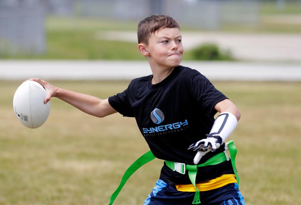 Chandler Maney, 10, looks to pass during a Howard-Suamico Youth Flag Football practice on Friday at Idlewild Park in Suamico before the NFL FLAG Football regional tournament at the Green Bay Packers' Ray Nitschke Field.