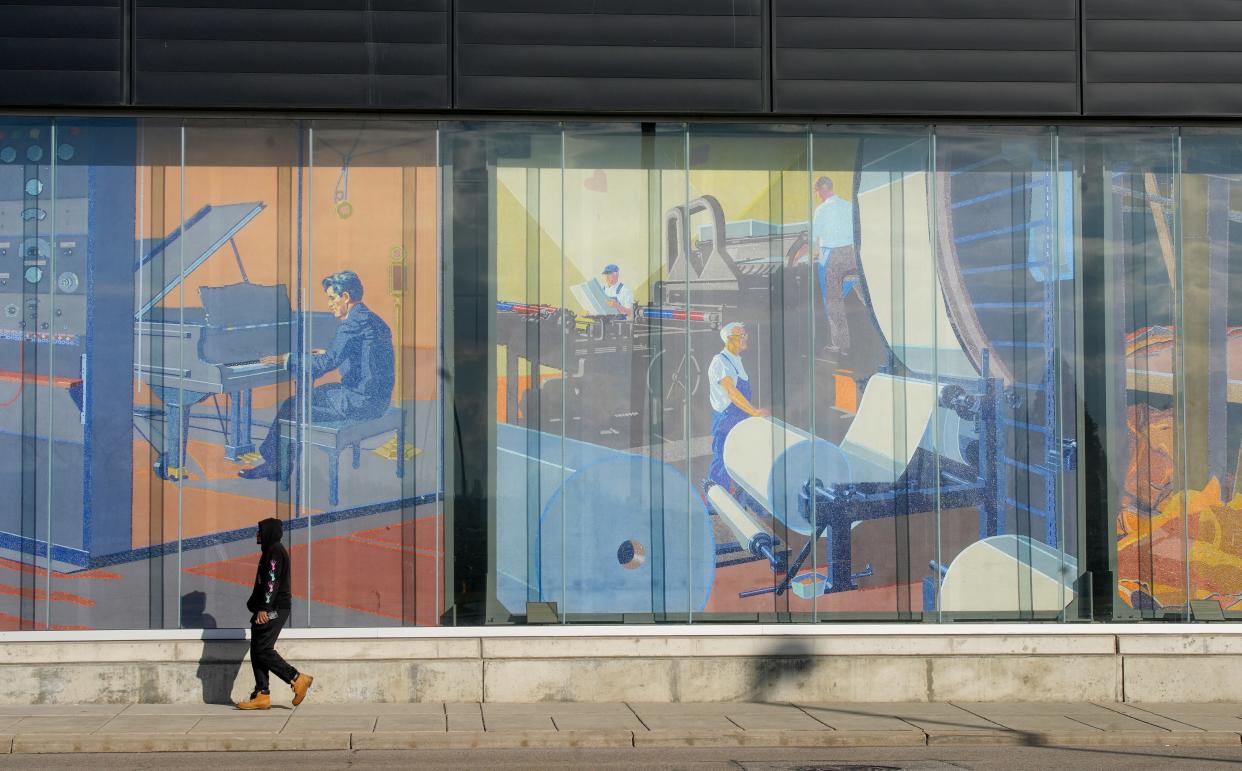 A man walks past the Winold Reiss mosaic murals at the Duke Energy Convention Center in downtown Cincinnati on Feb. 15, 2024. The murals were created for Cincinnati Union Terminal in the early 1930s.