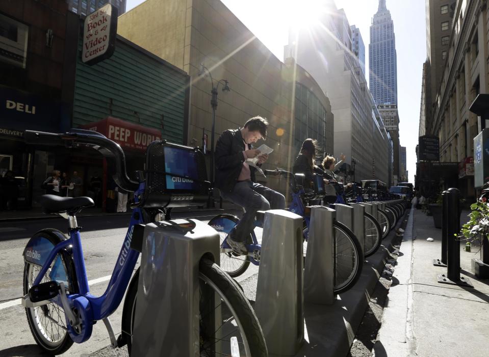 Tourists sit on bikes that are available as part of a bike share program Monday, May 27, 2013, in New York. The privately funded Citi Bike bike-share program will launch with 6,000 bikes at 330 docking stations in Manhattan and parts of Brooklyn. Officials hope to expand to 10,000 bikes and 600 docking stations in Manhattan, Brooklyn and Queens. (AP Photo/Frank Franklin II)