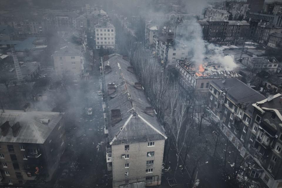 An aerial frame of a city with smoke rises from burning apartment buildings