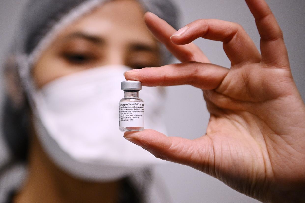 A health worker holds a vial containing the Pfizer/BioNTech Covid-19 vaccine on January 6, 2021, in Aulnay-sous-Bois, as several French medical representatives and personalities receive the vaccine. - France began its Covid-19 vaccination campaign on December 27, 2020. The French government has faced criticism over the slow progress of its drive to vaccinate people, a problem compounded by the high levels of public scepticism about the campaign. (Photo by Christophe ARCHAMBAULT / POOL / AFP) (Photo by CHRISTOPHE ARCHAMBAULT/POOL/AFP via Getty Images)