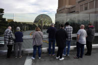 People stop to take pictures of the Sphere on a pedestrian bridge along the Las Vegas Strip, Wednesday, Jan. 17, 2024, in Las Vegas. Stopping or standing is prohibited on Las Vegas Strip pedestrian bridges after a new ordinance took effect Tuesday, Jan. 17, 2024. (AP Photo/John Locher)