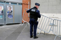 A policeman installs barriers near a polling station during the first round of 2017 French presidential election in Henin-Beaumont, France, April 23, 2017. REUTERS/Pascal Rossignol