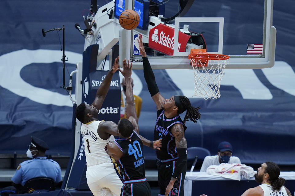 New Orleans Pelicans forward Zion Williamson (1) goes in for a layup against Sacramento Kings forward Harrison Barnes (40) and center Richaun Holmes in the first half of an NBA basketball game in New Orleans, Monday, April 12, 2021. (AP Photo/Gerald Herbert)