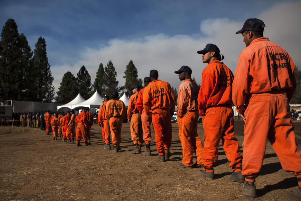 Inmate firefighters line up for dinner at the Rim Fire camp near Buck Meadows, California, August 26, 2013. The fire has burned 160,980 acres on the northwest side of Yosemite National Park. REUTERS/Max Whittaker (UNITED STATES - Tags: ENVIRONMENT DISASTER)