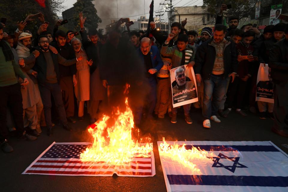Protesters in Lahore burn American and Israeli flags.&nbsp; (Photo: ARIF ALI via Getty Images)