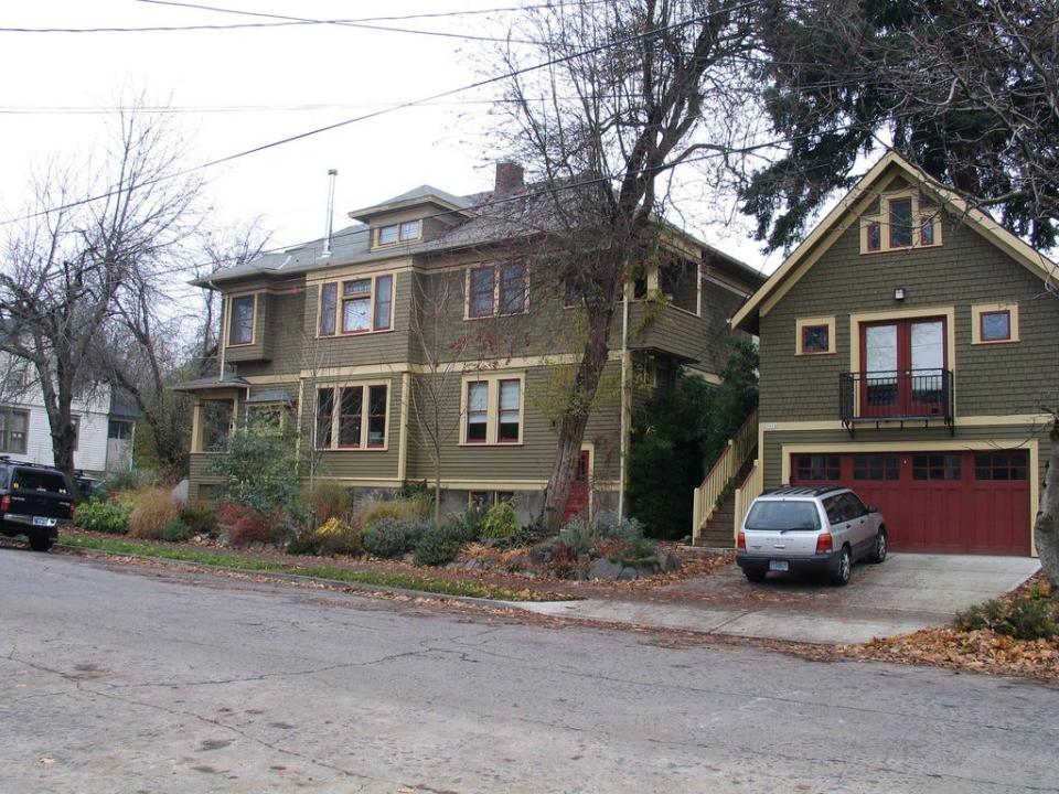 An urban lot with two residences, a single-family home shown at left, and an ADU, accessory dwelling unit, at right, over a garage.