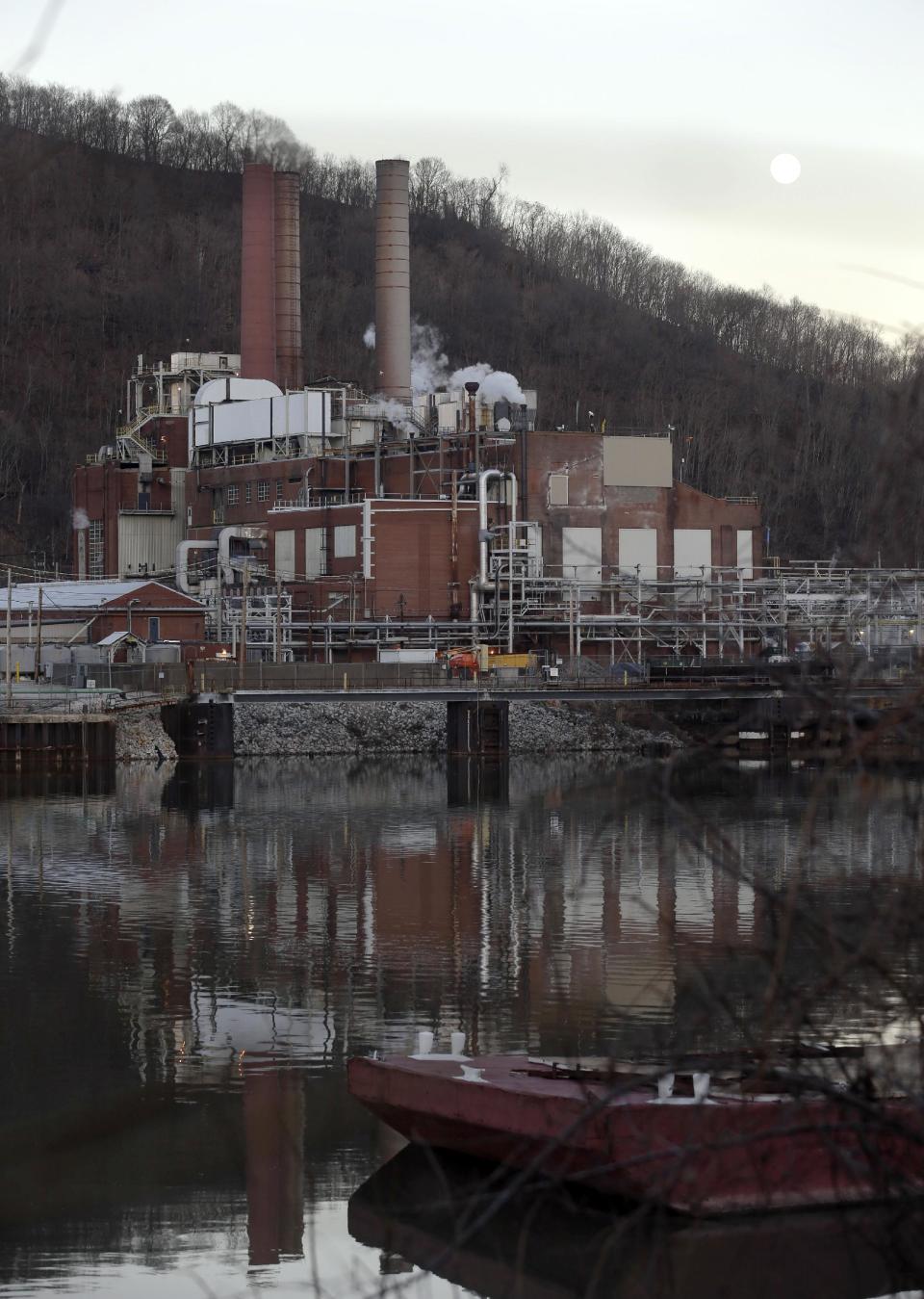 In this photo taken on Tuesday, Jan. 14, 2014, the moon rises over a chemical plant that sits along the banks of the Kanawha river in Marmet, W.Va. While no one became seriously ill from last week's chemical spill a storage facility in Charleston, W.Va, some homeland security experts said the emergency was proof the United States has not done nearly enough to protect water systems from accidental spills or deliberate contamination. (AP Photo/Steve Helber)