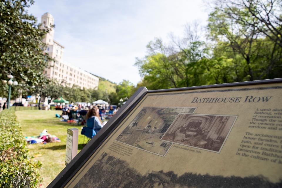 People can be seen with telescopes and lawn chairs as they wait for the total solar eclipse on Arlington Lawn at Hot Springs National Park next to Bathhouse Row in Hot Springs, Arkansas on Monday, April 8, 2024.