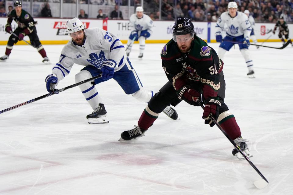 Arizona Coyotes left wing Michael Carcone (53) carries the puck in front of Toronto Maple Leafs defenseman Timothy Liljegren during the third period of an NHL hockey game Wednesday, Feb. 21, 2024, in Tempe, Ariz. (AP Photo/Rick Scuteri)