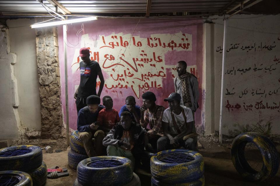 In this Jan. 10, 2020 photo, Sudanese activist and artist Youssef al-Sewahly, bottom left, gathers with his friends at the Revolutionary Martyrs Center, in Khartoum, Sudan. When al-Sewahly took to the streets in Sudan late in 2018, he and the other protesters had one goal: to remove the autocratic regime of Omar al-Bashir and replace it with a civilian-led government. They’ve achieved the former, but the latter still hangs in the balance. (AP Photo/Nariman El-Mofty)