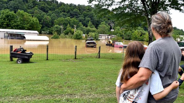 PHOTO: Bonnie Combs hugs her 10-year-old granddaughter Adelynn Bowling, as she watches  her property become covered by the North Fork of the Kentucky River in Jackson, Ky., July 28, 2022.  (Timothy D. Easley/AP)