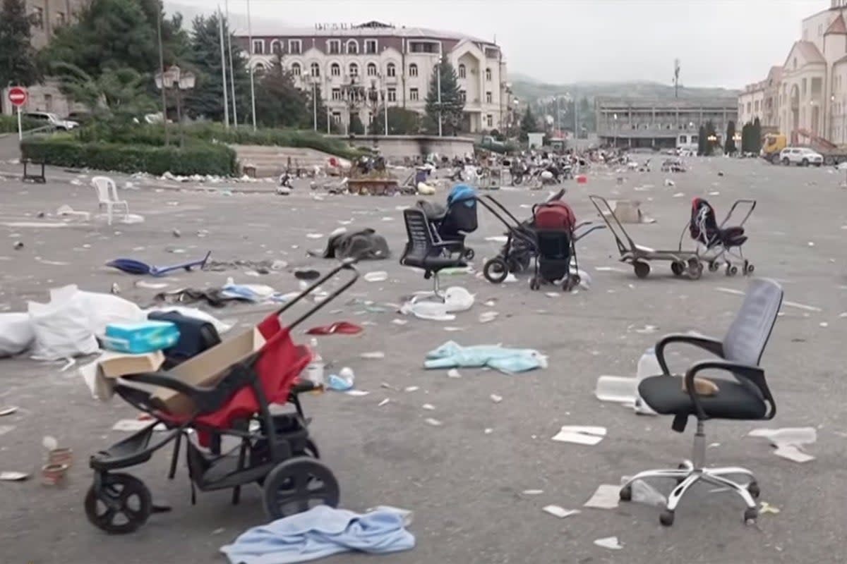 Prams and trolleys are abandoned in the street where residents waited to board buses (Al Jazeera/YouTube)