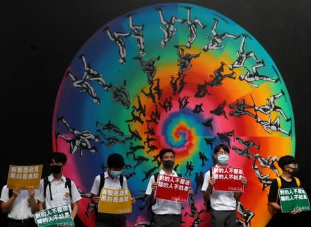 Secondary school students hold placards as they join a human chain protesting against what they say is police brutality against protesters, after clashes at Wan Chai district in Hong Kong