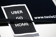 A leaflet which reads "Uber go home" is seen on a taxi as striking French taxi drivers block the traffic on the Paris ring road during a national protest against car-sharing service Uber, in Paris, France, June 25, 2015. (REUTERS/Charles Platiau)