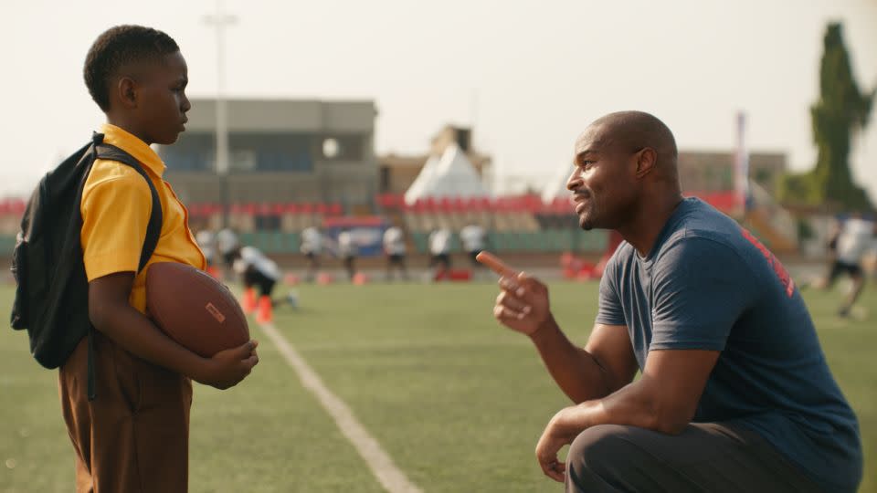 Umenyiora greets the boy, played by Eldad Osime, at the NFL camp during the commercial. - NFL