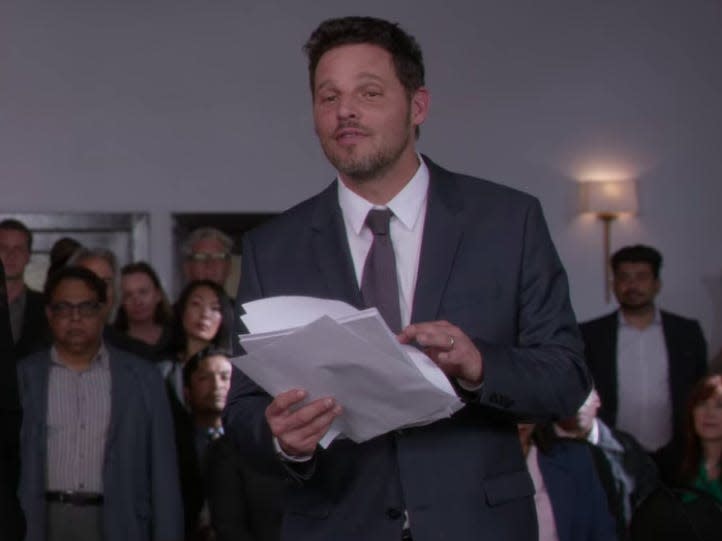 Alex Karev on Greys Anatomy holding papers and wearing a suit