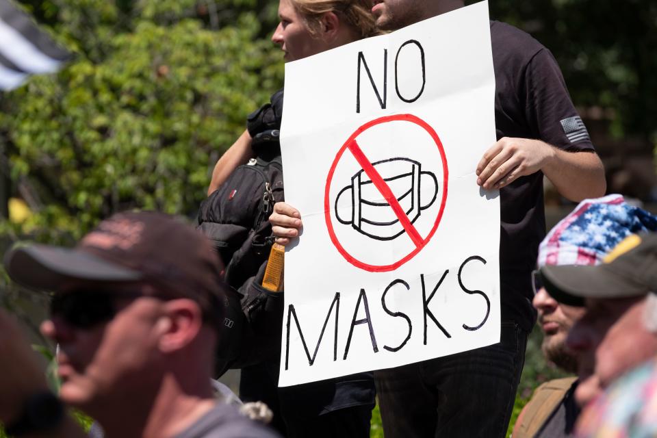 An anti-mask protestor holds up a sign in front of the Ohio Statehouse during a right-wing protest "Stand For America Against Terrorists and Tyrants" at State Capitol on July 18, 2020 in Columbus, Ohio. - Protestors descended on Columbus, Ohio for a planned anti-mask rally in response to local laws requiring people to wear a mask in many Ohio cities. (Photo by Jeff Dean / AFP) (Photo by JEFF DEAN/AFP via Getty Images)