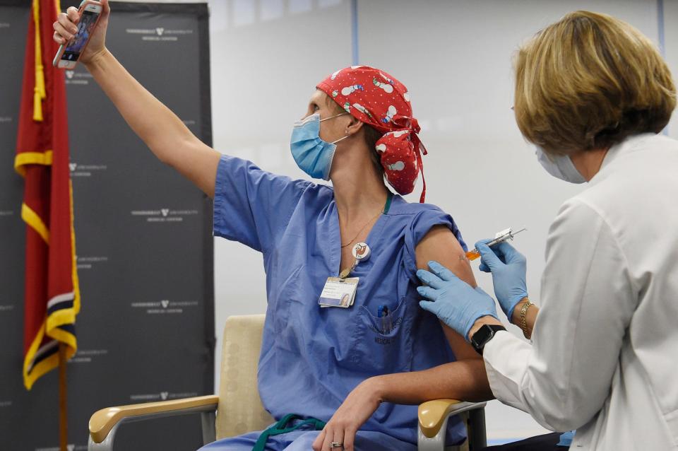 Nurse practitioner Lisa Flemmons takes a selfie as she receives a COVID-19 vaccine at Vanderbilt University Medical Center in Nashville, Tenn., Thursday, Dec. 17, 2020.