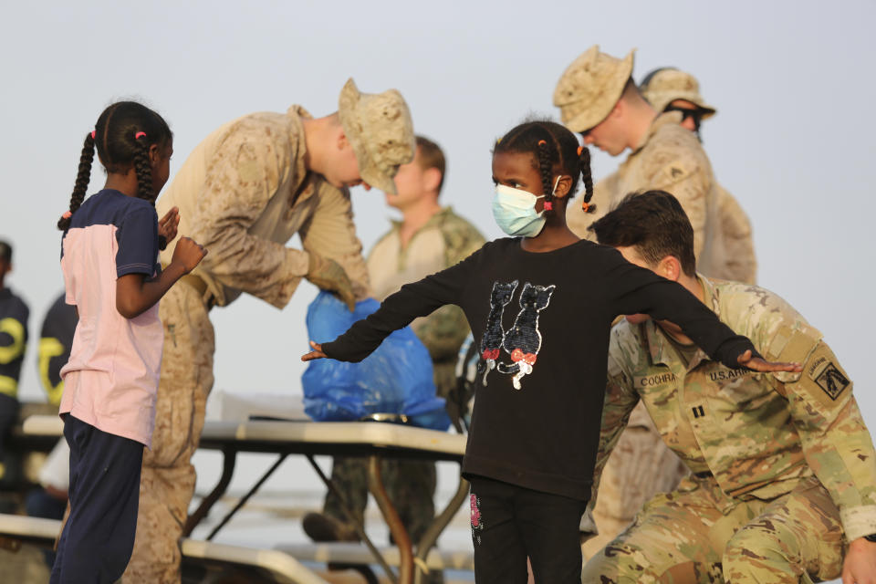 American nationals are searched by the U.S. soldiers before boarding a ship in Port Sudan, Sunday, April 30, 2023. Sudan's army and its rival paramilitary say they will extend a humanitarian cease-fire another 72 hours as of midnight. The decision follows international pressure to allow the safe passage of civilians and aid but also comes after days of continued fighting despite the earlier truce. (AP Photo/Smowal Abdalla)