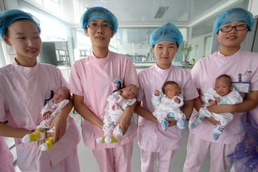 Nurses carry 30-day-old quadruplets, two baby girls and two baby boys, as they pose for a photo at a hospital in Lianyungang, in east China's Jiangsu province. The world population will reach seven billion later this year, with increases in the number of people in Africa off-setting birth rate drops elsewhere, according to a new French study published Thursday