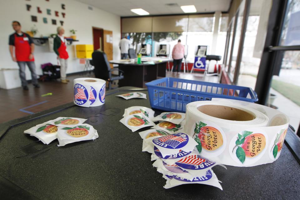 Georgia voting stickers sit atop an extra voting machine in Athens. Ga.