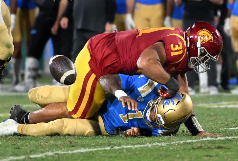 Pasadena, California November 19, 2022- UCLA quarterback Dorain Thompson-Robinson fumbles the ball while being sacked by USC's Tyronne Taleri in the third quarter at the Rose Bowl Saturday. (Wally Skalij/Los Angeles Times)