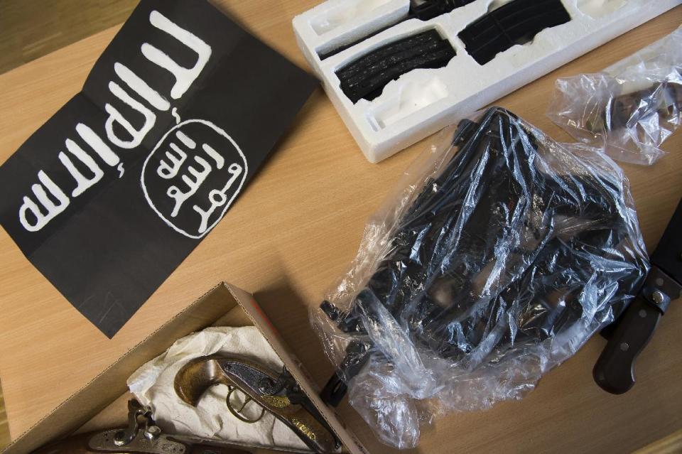 Seized weapons and an IS flag are on display during a news conference of the police in Goettingen, Germany, Thursday, Feb. 9, 2017. Twelve properties were searched in a raid in Goettingen. Police in central Germany say they have detained two known Islamic extremists in an investigation of possible plans for an attack. (Swn Pfoertner/dpa via AP)