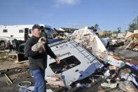 Damon Braley carries his mother's dog Sammy, which he rescued from under the wreckage of his parents' RV, at the Roadrunner RV Park in Oklahoma City, Oklahoma May 7, 2015. About a dozen people were injured by a series of tornadoes that touched down southwest of Oklahoma City, part of a storm system that flattened structures and caused severe flooding in several Great Plain states, officials said on Thursday. REUTERS/Nick Oxford