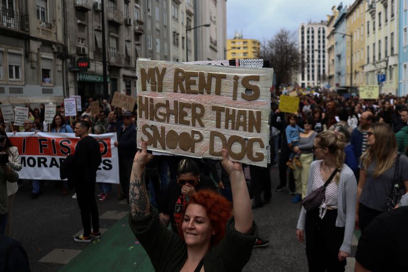 Una mujer lleva una pancarta en inglés que dice "Mi renta es más alta que Snoop Dog" durante una manifestación por el derecho a una vivienda asequible en Lisboa, Portugal,