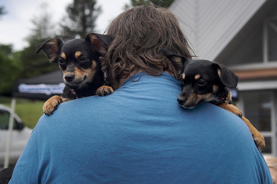 Jesse Smathers holds his puppies, Ruby, right, and Lola, as they wait to be seen by a veterinarian May 17, 2023 at Emma Fellowship Church.