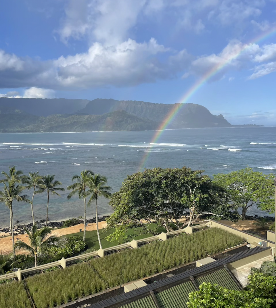 Daily passing rain showers in Hanalei Bay mean rainbows are a common occurrence. At the bottom of the image, indigenous pili grass helps collect stormwater and insulate the building.