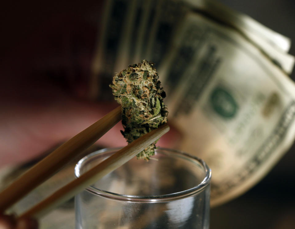 FILE - This Sept. 18, 2012 file photos shows a caregiver picking out a marijuana bud for a patient at a marijuana dispensary in Denver. After all the economy-focused campaign talk, voters in some states will get a chance on Election Day to sound off on intriguing topics that the presidential rivals ignored, including marijuana legalization, death penalty repeal and assisted suicide.(AP Photo/Ed Andrieski, File)