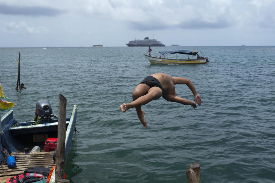 Un joven se sumerge en el mar desde la isla Gardí Sugdub, parte del archipiélago de San Blas frente a la costa caribeña de Panamá, el domingo 26 de mayo de 2024. Debido al aumento del nivel del mar, unas 300 familias indígenas Guna se trasladarán a nuevas casas construidas por el gobierno en tierra firme. (Foto AP/Matías Delacroix)